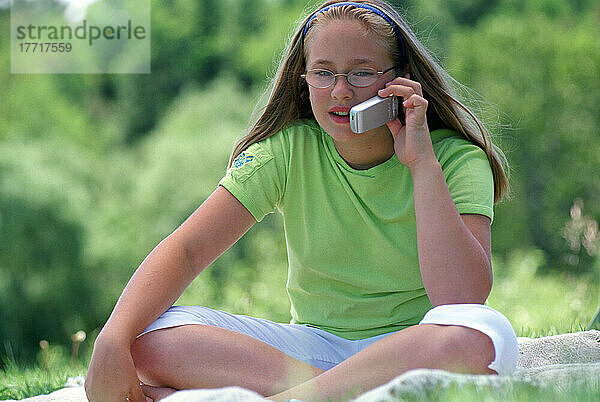 Mädchen im Gespräch auf Handy im Freien