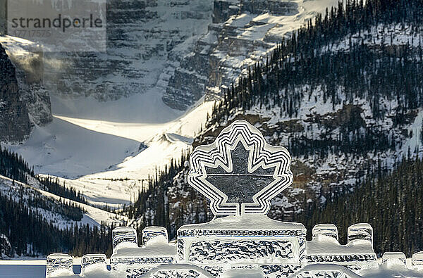 Kanadische Ahornblatt-Eisskulptur vor dem Hintergrund eines schneebedeckten Berges im Banff National Park; Lake Louise  Alberta  Kanada