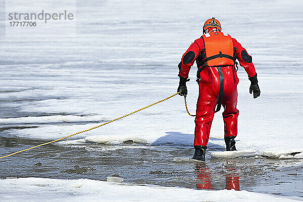 Such- und Rettungsdienstmitarbeiter  der auf dem zugefrorenen Assiniboine River einen Überlebensanzug für kaltes Wasser trägt. Winnipeg  Manitoba  Kanada.