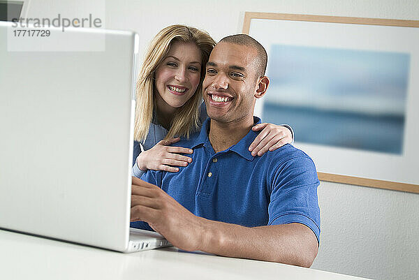 Junges Paar schaut auf den Computer