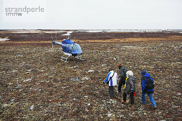 Menschen nähern sich einem Hubschrauber in der Tundra; Churchill  Manitoba  Kanada