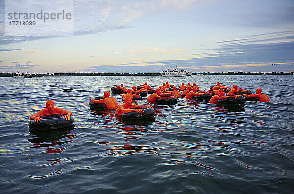 Amerikanische Kunstinstallation mit dem Namen Safety Orange Swimmers  die das Bewusstsein für Einwanderung repräsentiert und auf dem See im Hafen von Toronto schwimmt; Toronto  Ontario  Kanada