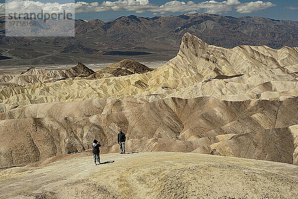 Wanderer  der ein Foto in den Badlands von Zabriskie Point im Death Valley National Park macht; Kalifornien Usa