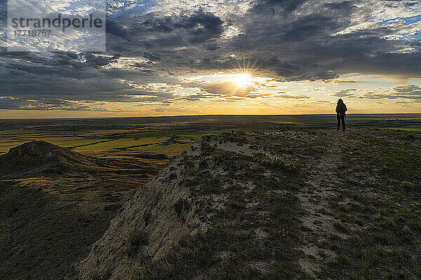 Frau  die den Sonnenuntergang über den Prärien von Saskatchewan beobachtet; Val Marie  Saskatchewan  Kanada
