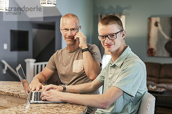 Vater und Sohn nutzen zu Hause gemeinsam Technologie; Edmonton  Alberta  Kanada