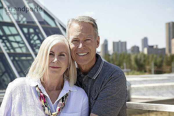 Porträt eines reifen Paares im Freien mit der Skyline der Stadt und Architektur im städtischen Hintergrund; Edmonton  Alberta  Kanada