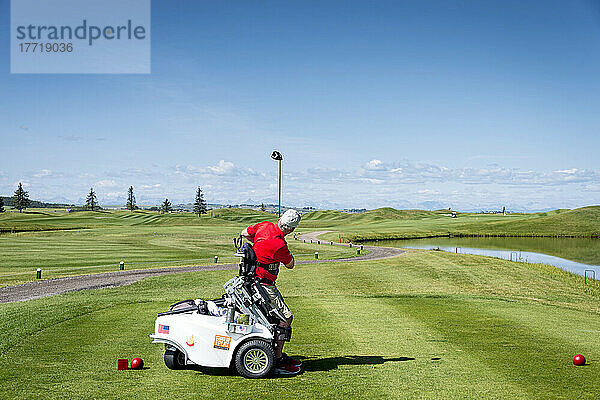 Behinderter Golfer  der einen speziellen motorisierten Hydraulik-Rollstuhl für den Golfsport benutzt; Okotoks  Alberta  Kanada