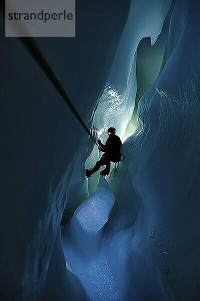 Ein Höhlenforscher und Glaziologe durchquert eine Gletschermühle.