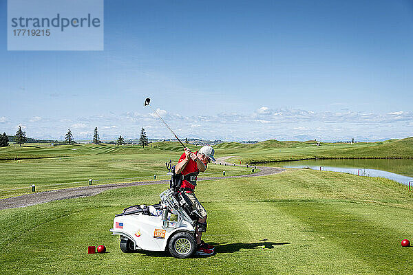 Behinderter Golfer  der einen speziellen motorisierten Hydraulik-Rollstuhl für den Golfsport benutzt; Okotoks  Alberta  Kanada