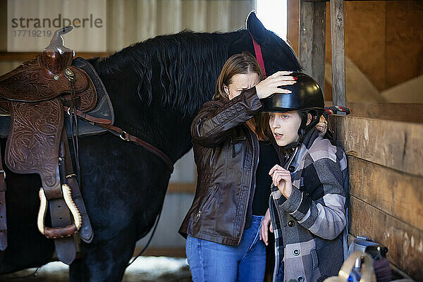Ein junges Mädchen mit zerebraler Lähmung und ihre Mutter bereiten sich auf eine Hippotherapie-Sitzung mit dem Pferd vor; Westlock  Alberta  Kanada