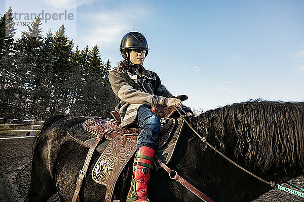 Ein junges Mädchen mit zerebraler Lähmung reitet während einer Hippotherapie-Sitzung auf einem Pferd; Westlock  Alberta  Kanada