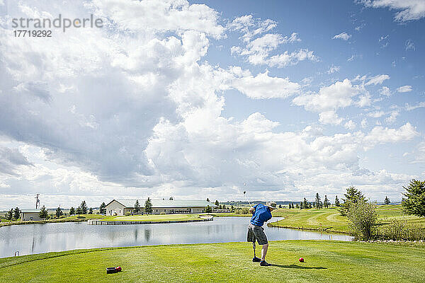 Amputierter mit Beinprothese schlägt den Ball auf dem Golfplatz; Okotoks  Alberta  Kanada