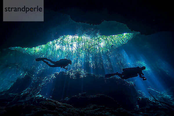 Silhouette eines Höhlentauchers bei der Erkundung einer Cenote oder eines Erdlochs; Tulum  Quintana Roo  Mexiko