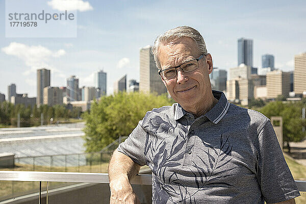 Außenporträt eines älteren Mannes mit Brille  Skyline der Stadt im Hintergrund; Edmonton  Alberta  Kanada