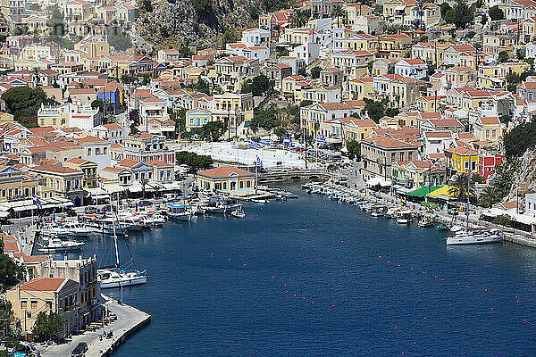 Überblick über das Stadtzentrum von Symi und Boote  die entlang der Küste im Hafen von Gialos auf der Insel Symi (Simi) festgemacht sind; Dodekanes-Inselgruppe  Griechenland