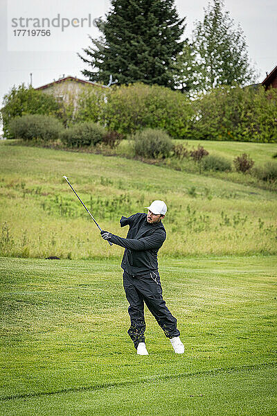 Einarmiger Amputierter beim Schwingen auf dem Golfplatz; Okotoks  Alberta  Kanada