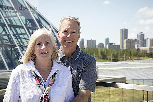Porträt eines reifen Paares im Freien mit der Skyline der Stadt und Architektur im städtischen Hintergrund; Edmonton  Alberta  Kanada