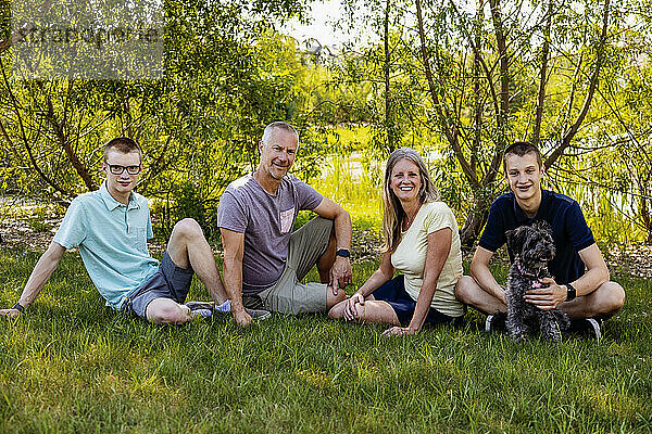 Familienporträt im Freien in einem Park mit zwei Teenager-Söhnen und einem Hund; Edmonton  Alberta  Kanada