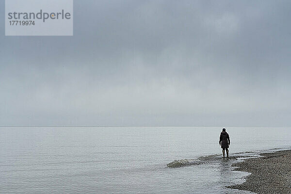 Stehende Frau mit Blick auf den See  der den Point Pelee National Park  Ontario  umgibt; Point Pelee  Ontario  Kanada