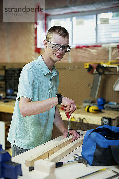 Junger Mann bei der Holzbearbeitung in seinem Keller; Edmonton  Alberta  Kanada