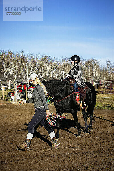 Ein Trainer arbeitet mit einem jungen Mädchen mit zerebraler Lähmung während einer Hippotherapie-Sitzung; Westlock  Alberta  Kanada