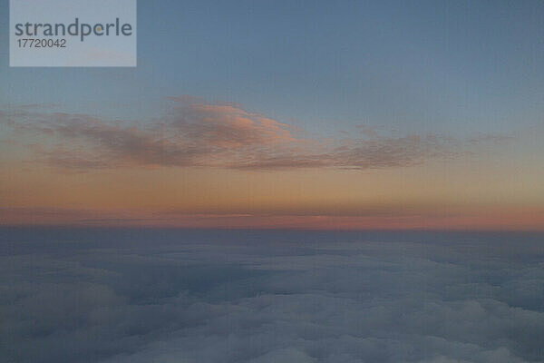 Wolken  die bei Sonnenuntergang über der Wolkendecke leuchten  gesehen von einem Flugzeug aus; Kanada
