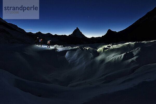 Das Matterhorn erhebt sich über Höhlenforscher  die auf dem Gornergletscher wandern.