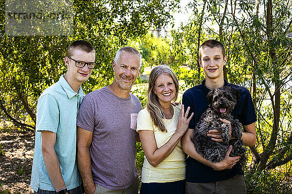 Familienporträt im Freien in einem Park mit zwei Teenager-Söhnen und einem Hund; Edmonton  Alberta  Kanada