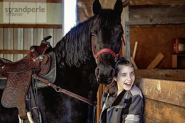 Ein junges Mädchen mit Cerebralparese mit einem Pferd in einer Scheune während einer Hippotherapie-Sitzung; Westlock  Alberta  Kanada