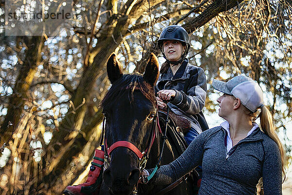 Ein junges Mädchen mit Cerebralparese und ihr Trainer arbeiten mit einem Pferd bei einem Ausritt während einer Hippotherapie-Sitzung; Westlock  Alberta  Kanada