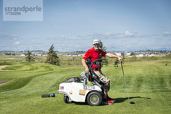 Behinderter Golfer  der einen speziellen motorisierten Hydraulik-Rollstuhl für den Golfsport benutzt; Okotoks  Alberta  Kanada