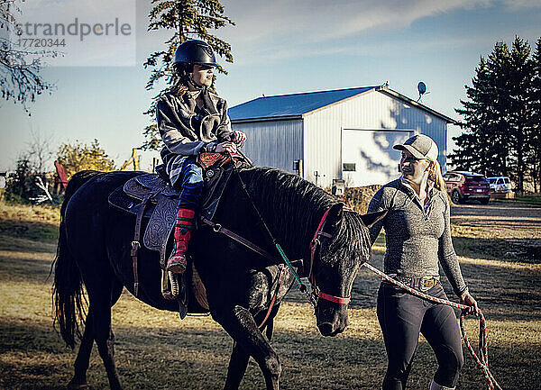 Ein junges Mädchen mit Cerebralparese und ihr Trainer arbeiten mit einem Pferd während einer Hippotherapie-Sitzung; Westlock  Alberta  Kanada
