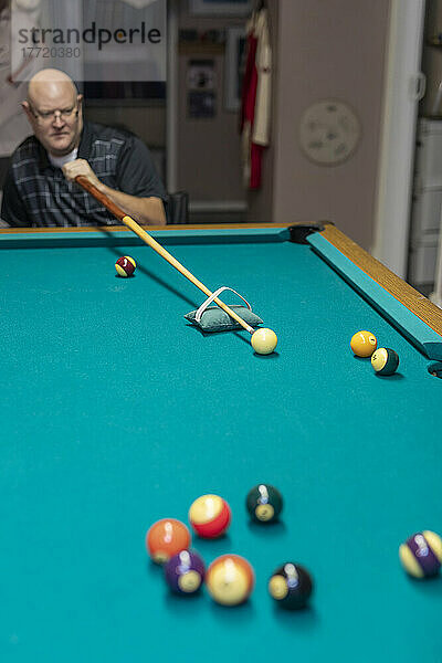 Mann mit doppelter Gliedmaßenamputation spielt zu Hause Billard; St. Albert  Alberta  Kanada