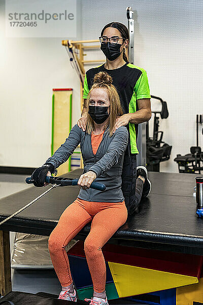 Eine querschnittsgelähmte Frau trainiert mit ihren Trainern an einem Rudergerät; Edmonton  Alberta  Kanada