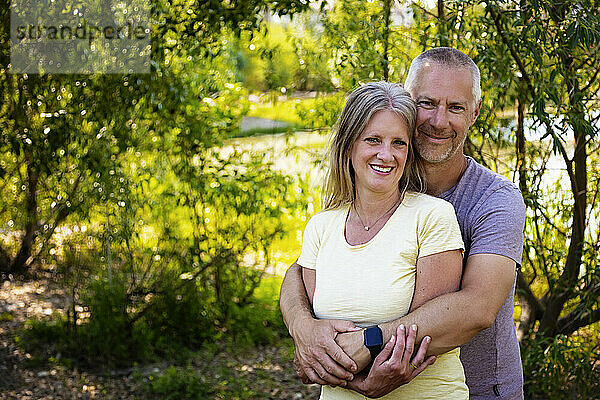 Porträt eines reifen Ehepaars im Freien  stehend in einem Park; Edmonton  Alberta  Kanada