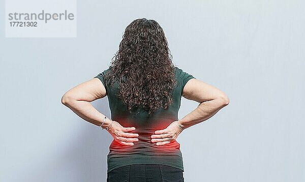 Person mit Wirbelsäulenproblemen  Frau mit Rückenproblemen auf isoliertem Hintergrund  Konzept einer Frau mit Lendenproblemen  eine wunde Frau mit Rückenschmerzen