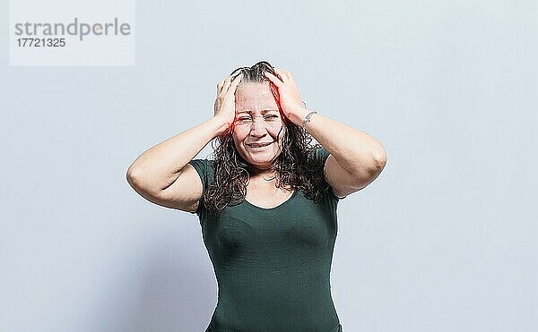 Frau mit Kopfschmerzen auf isoliertem Hintergrund  Konzept einer Person mit Kopfschmerzen  Frau gibt sich eine Kopfmassage  Konzept eines Mannes mit Migräne