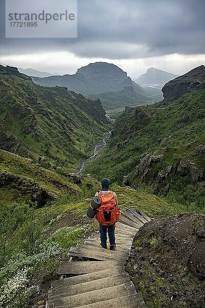 Wanderer auf Wanderweg mit Stufen  Berglandschaft mit Flusstal  hinten Bergtal mit Fluss Krossá und Berg Valahnúkur  vulkanische Landschaft am Wanderweg Fimmvörðuháls  Þórsmörk Nature Reserve  Suðurland  Island  Europa