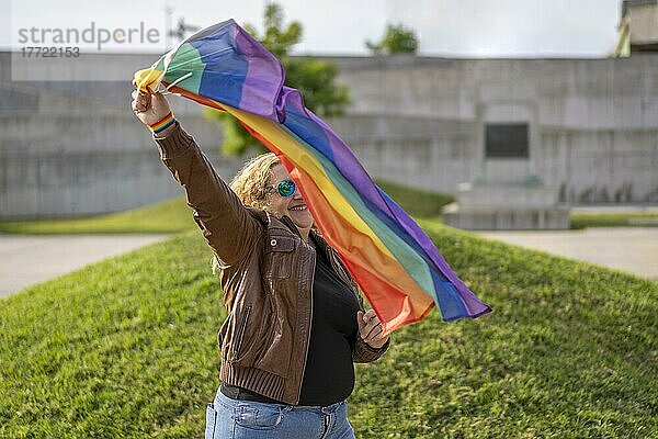 Junge blonde Frau hält Igbt-Flagge. Konzept der Freiheit und Toleranz