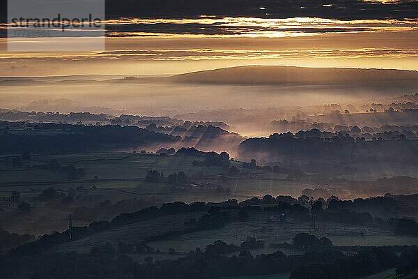 Morgensonnenstrahlen und Frühnebel bedecken die Cheshire-Ebene bei Sonnenaufgang  von Bosley Cloud  Cheshire  England  Vereinigtes Königreich  Europa