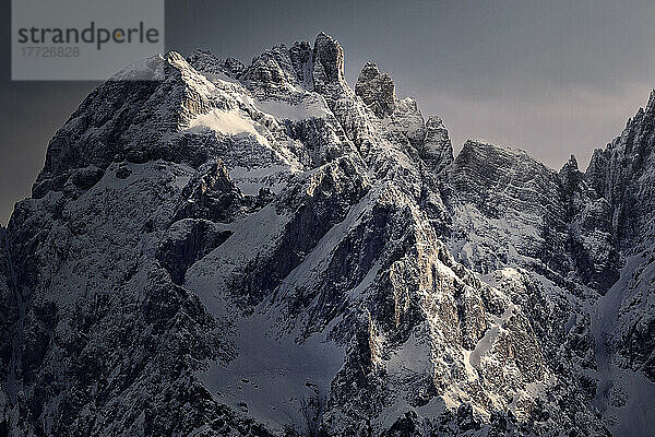 Verschneiter Dolomitengipfel  der bei Sonnenuntergang vom Sonnenlicht getroffen wird  Dolomiten  Trentino-Südtirol  Italien  Europa