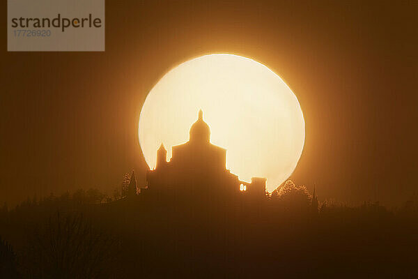 Sonne hinter der Silhouette der Wallfahrtskirche San Luca bei Sonnenuntergang  Bologna  Emilia Romagna  Italien  Europa