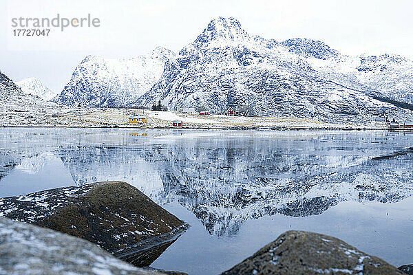 Majestätische Berggipfel spiegeln sich im Winter im eisigen Meer  Flakstadpollen  Flakstadoya  Nordland  Lofoten  Norwegen  Skandinavien  Europa