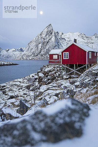 Rote Fischerhütten in der Abenddämmerung mit Schnee bedeckt  Hamnoy  Kreis Nordland  Lofoten  Norwegen  Skandinavien  Europa