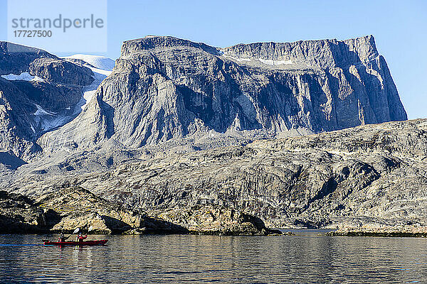 Zwei Kajakfahrer auf dem Wasser vor der felsigen Küste  Grönland.