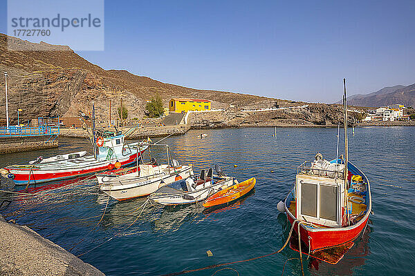 Blick auf bunte Boote im Hafen und Berge im Hintergrund  Puerto de La Aldea  Gran Canaria  Kanarische Inseln  Spanien  Atlantik  Europa