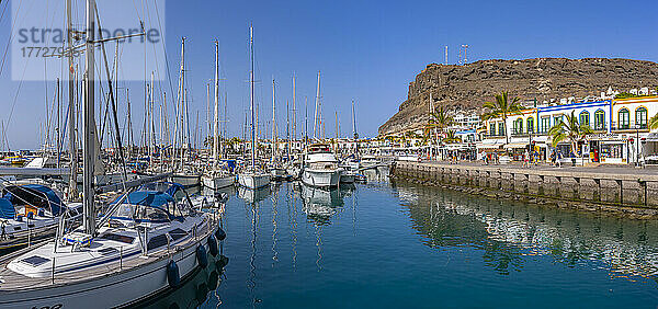 Blick auf Boote und farbenfrohe Gebäude entlang der Promenade in der Altstadt  Puerto de Mogan  Gran Canaria  Kanarische Inseln  Spanien  Atlantik  Europa