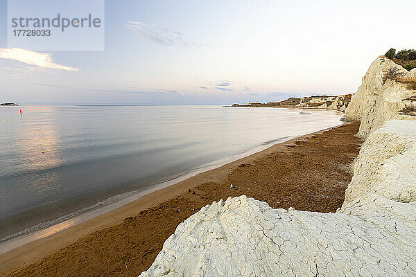 Ruhiges Meer im Morgengrauen  eingerahmt von Kalksteinfelsen mit Blick auf den goldenen Sand des Xi-Strands  Kefalonia  Ionische Inseln  griechische Inseln  Griechenland  Europa