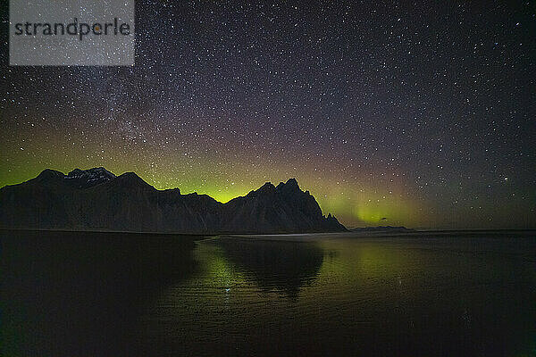 Nordlichter (Aurora Borealis) und Milchstraße über dem Berg Vestrahorn  reflektiert im Wasser  Halbinsel Stokksnes  Südostisland  Polarregionen