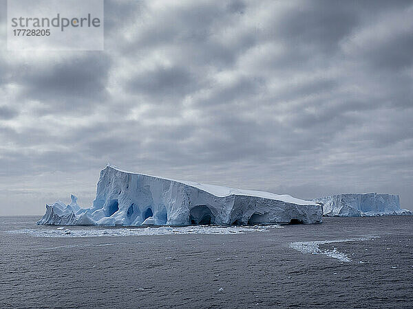 Ein großer Eisberg mit Löchern und Bögen bildete sich in der Nähe von Coronation Island  den Süd-Orkneys  der Antarktis und den Polarregionen